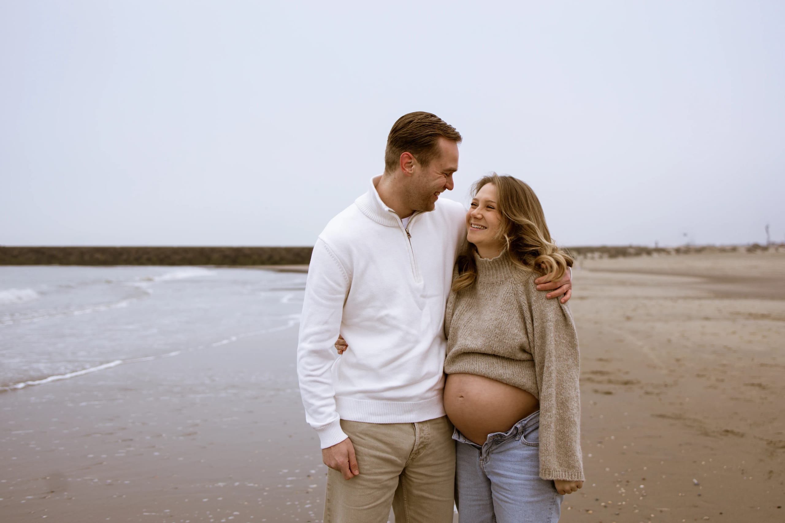 Liefdevolle zwangerschapsshoot reportage samen met partner in de natuur, waarbij de mooie zwangere buik prachtig wordt vastgelegd