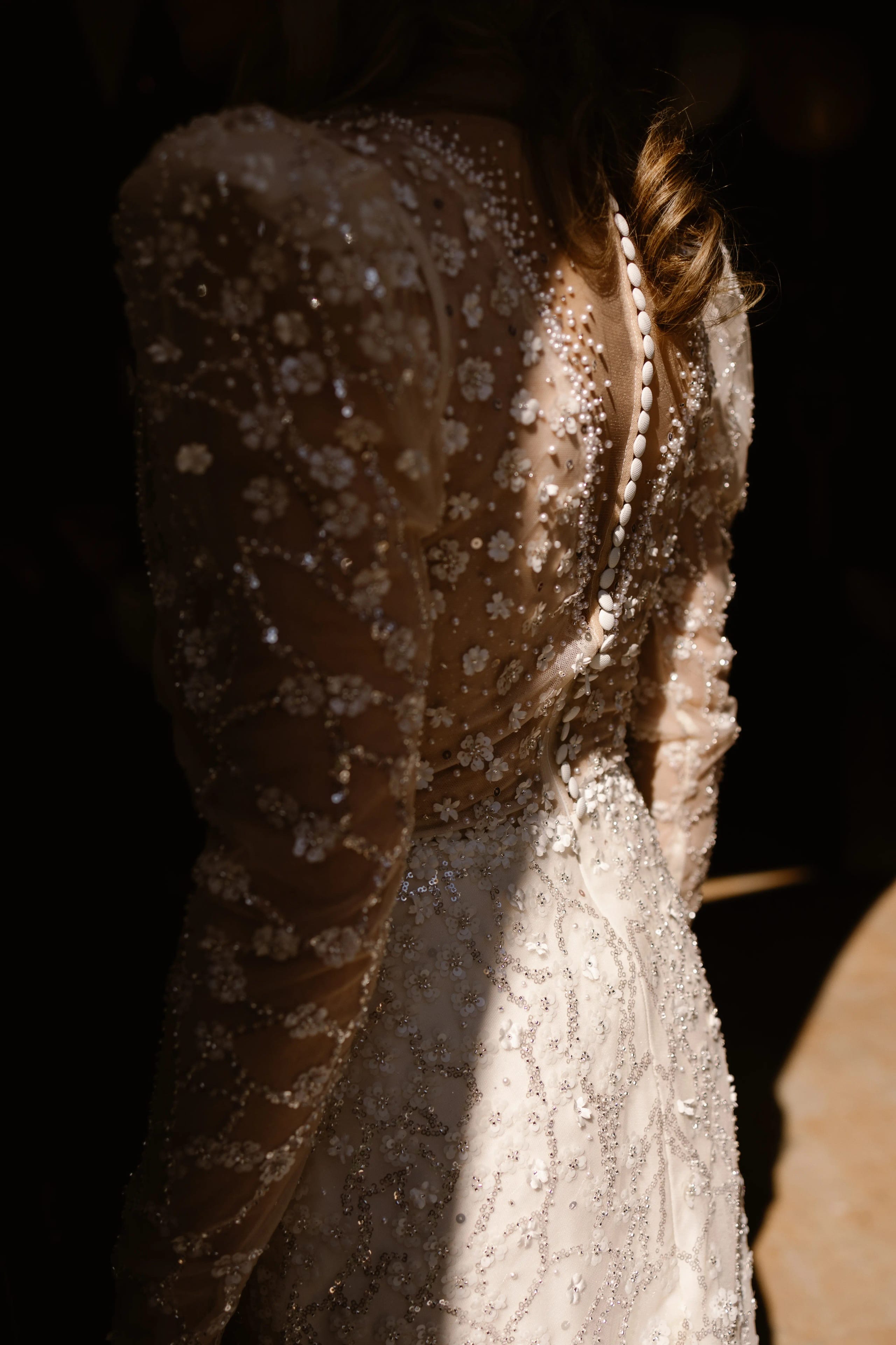 Detailfoto van de prachtig bewerkte rug van de trouwjurk met strass en glitters