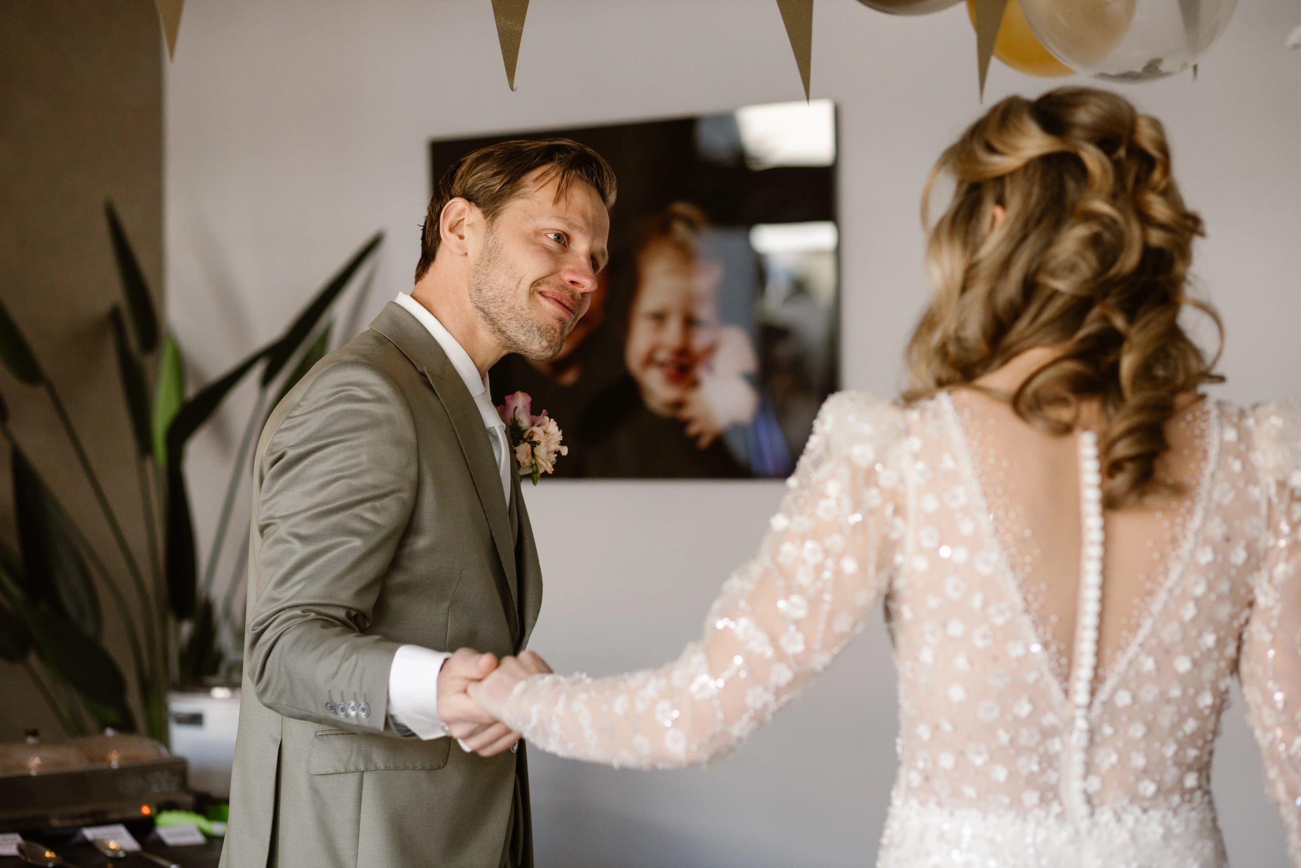 Bruidegom kijkt vol bewondering naar zijn prachtige bruid terwijl ze elkaars hand vasthouden