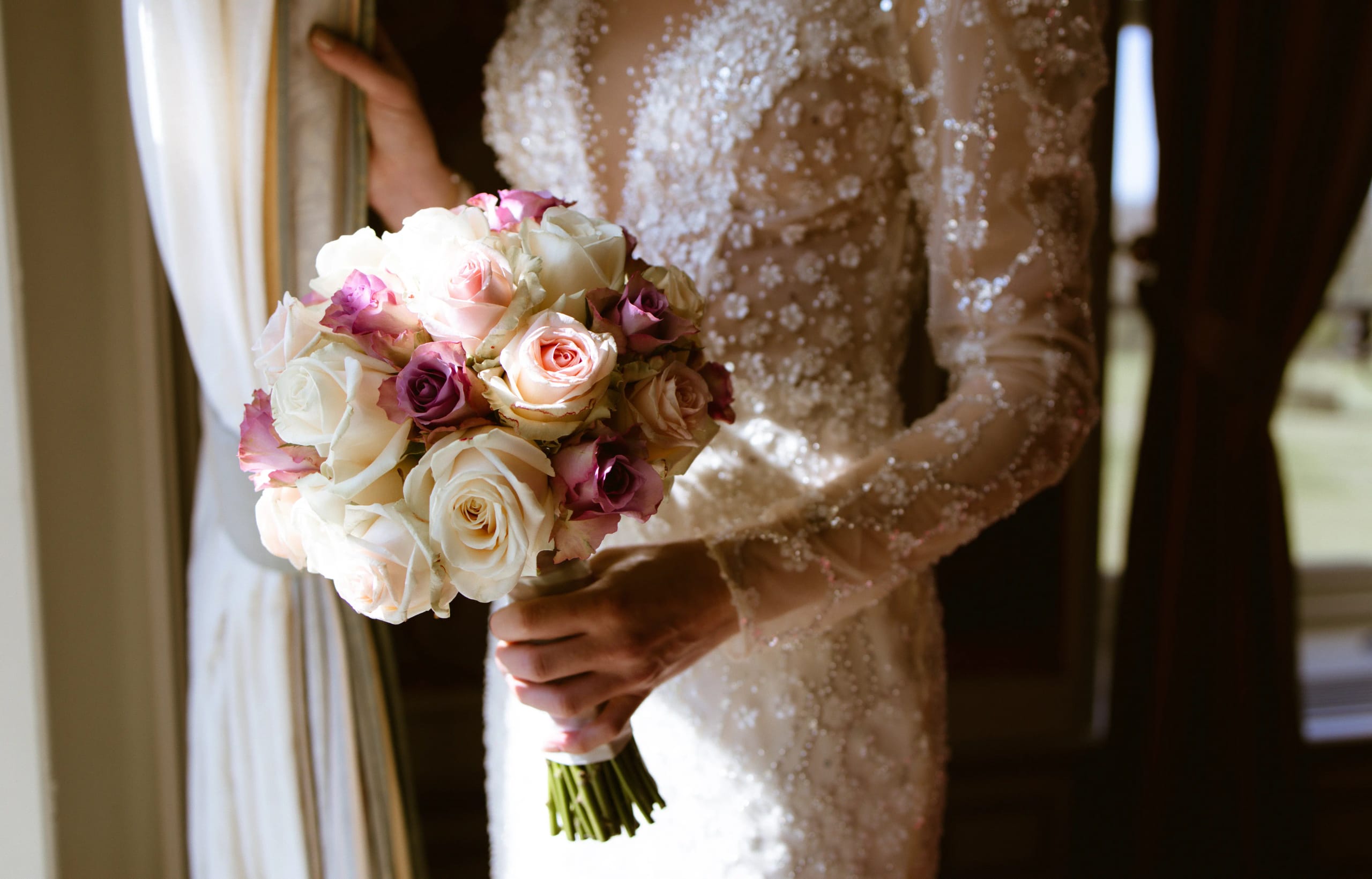 Detail van het elegante bruidsboeket met zachtroze en witte rozen