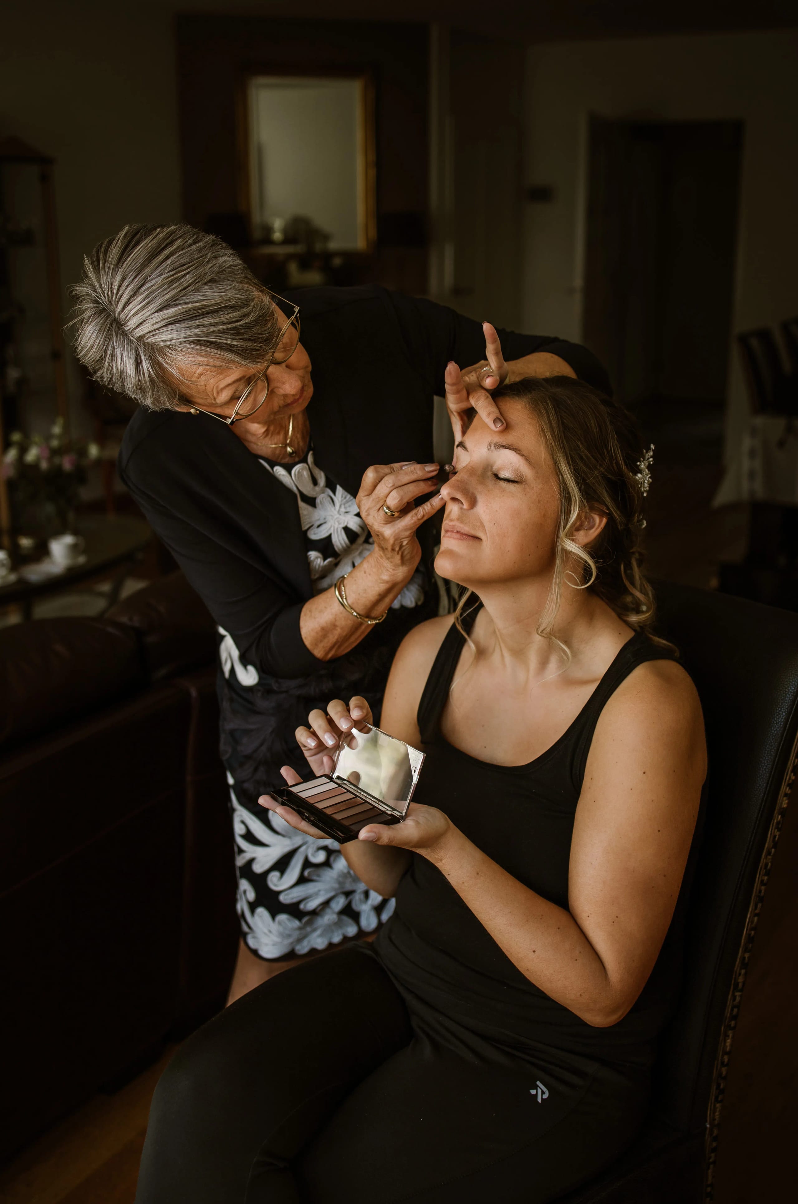 Detailopname van de bruid die haar make-up laat aanbrengen door een visagist
