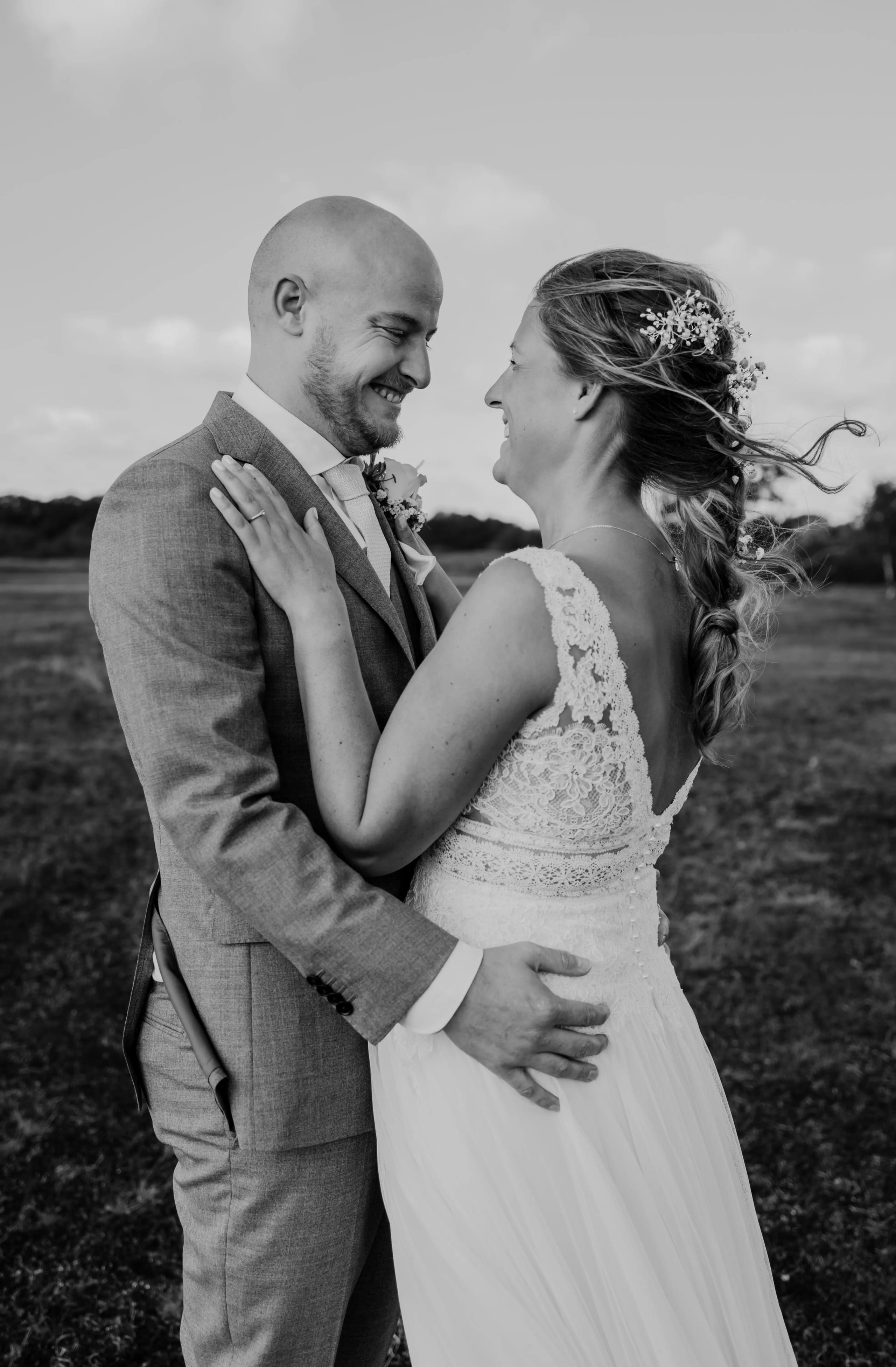 Zwart-wit portret van Denise en Hein die elkaar stralend aankijken in een duingebied