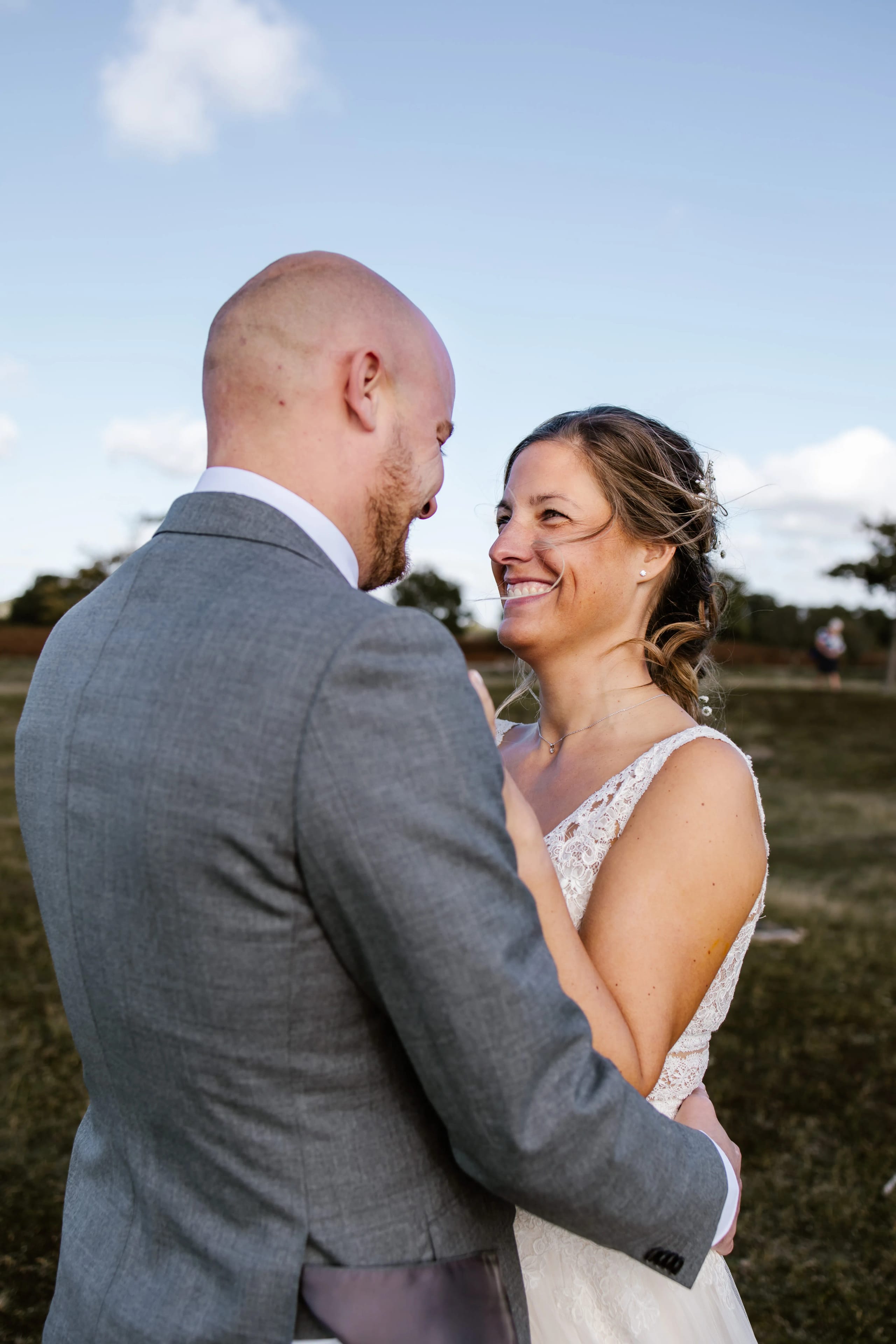 Romantisch portret van het bruidspaar Denise en Hein in de natuur tegen een blauwe lucht