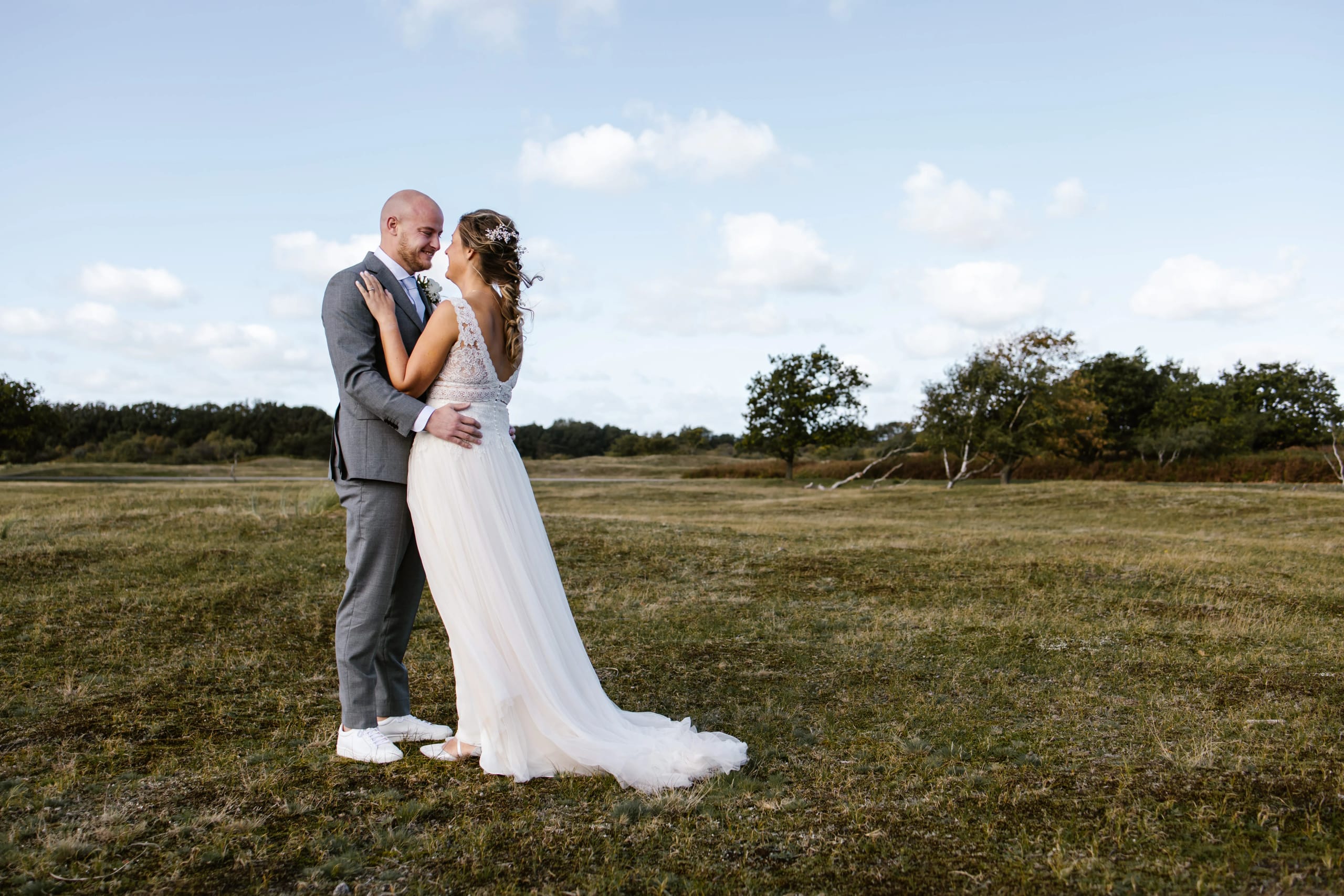 Full-body shot van het bruidspaar Denise en Hein in een prachtig natuurgebied