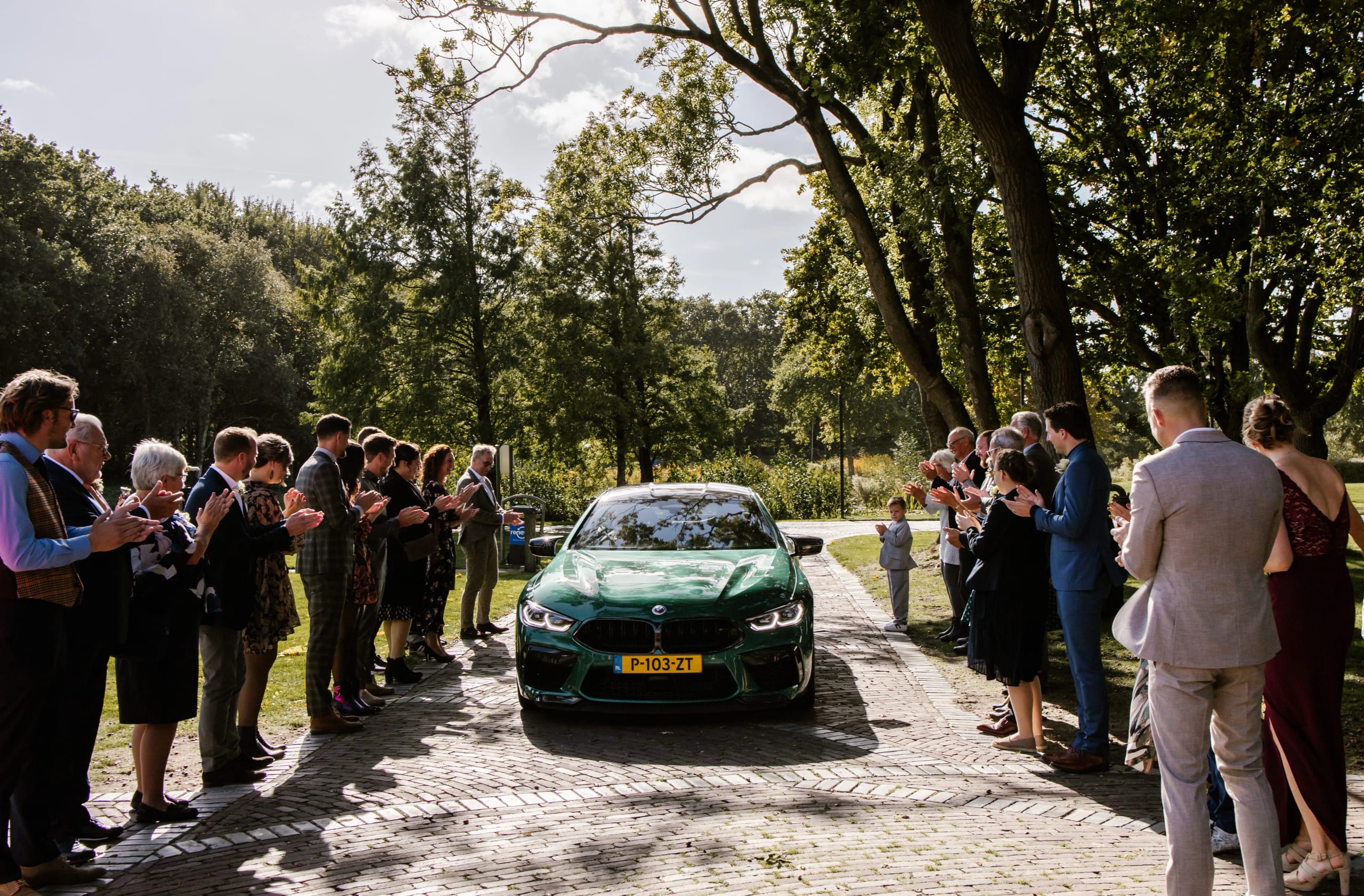 De bruid en bruidegom arriveren in een moderne groene sportwagen voor de ceremonie