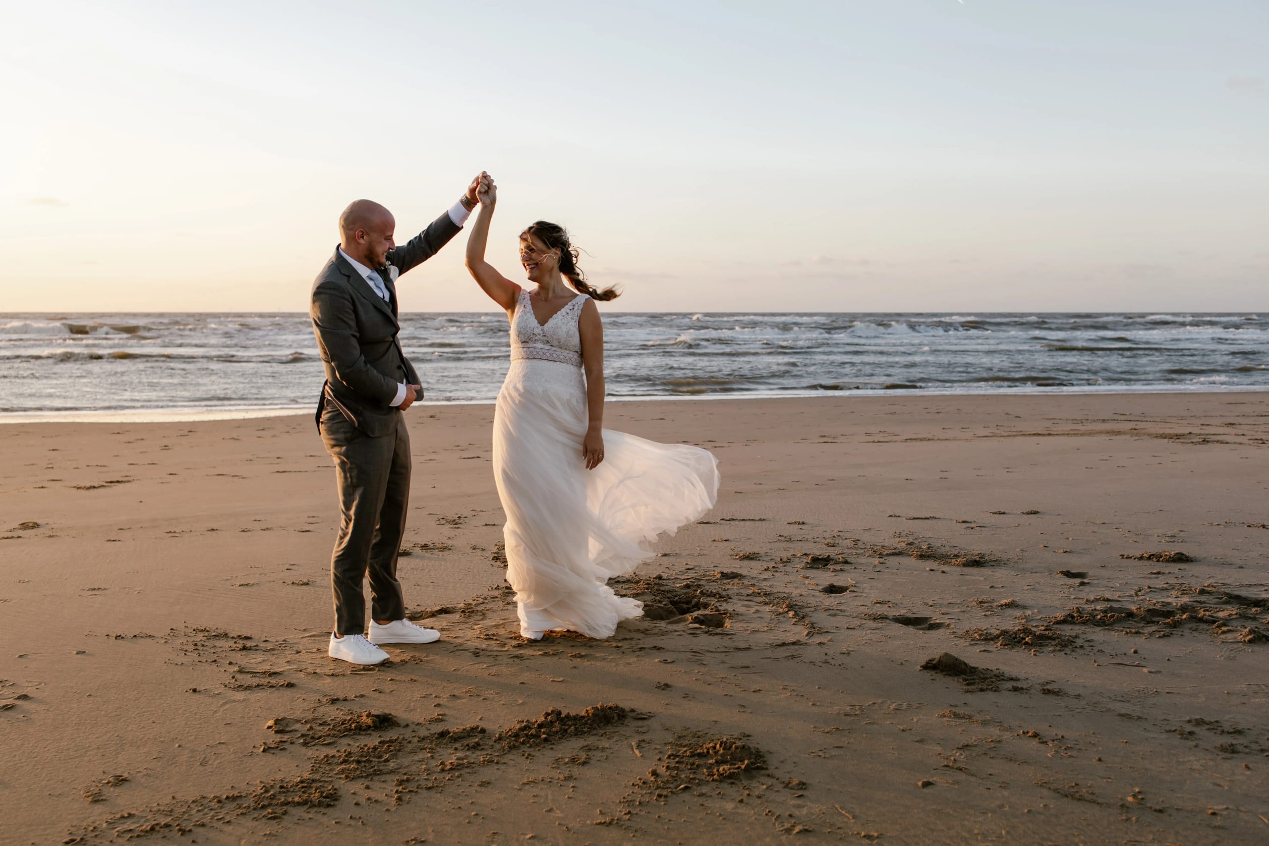 Denise en Hein doen een romantische dans op het strand bij zonsondergang