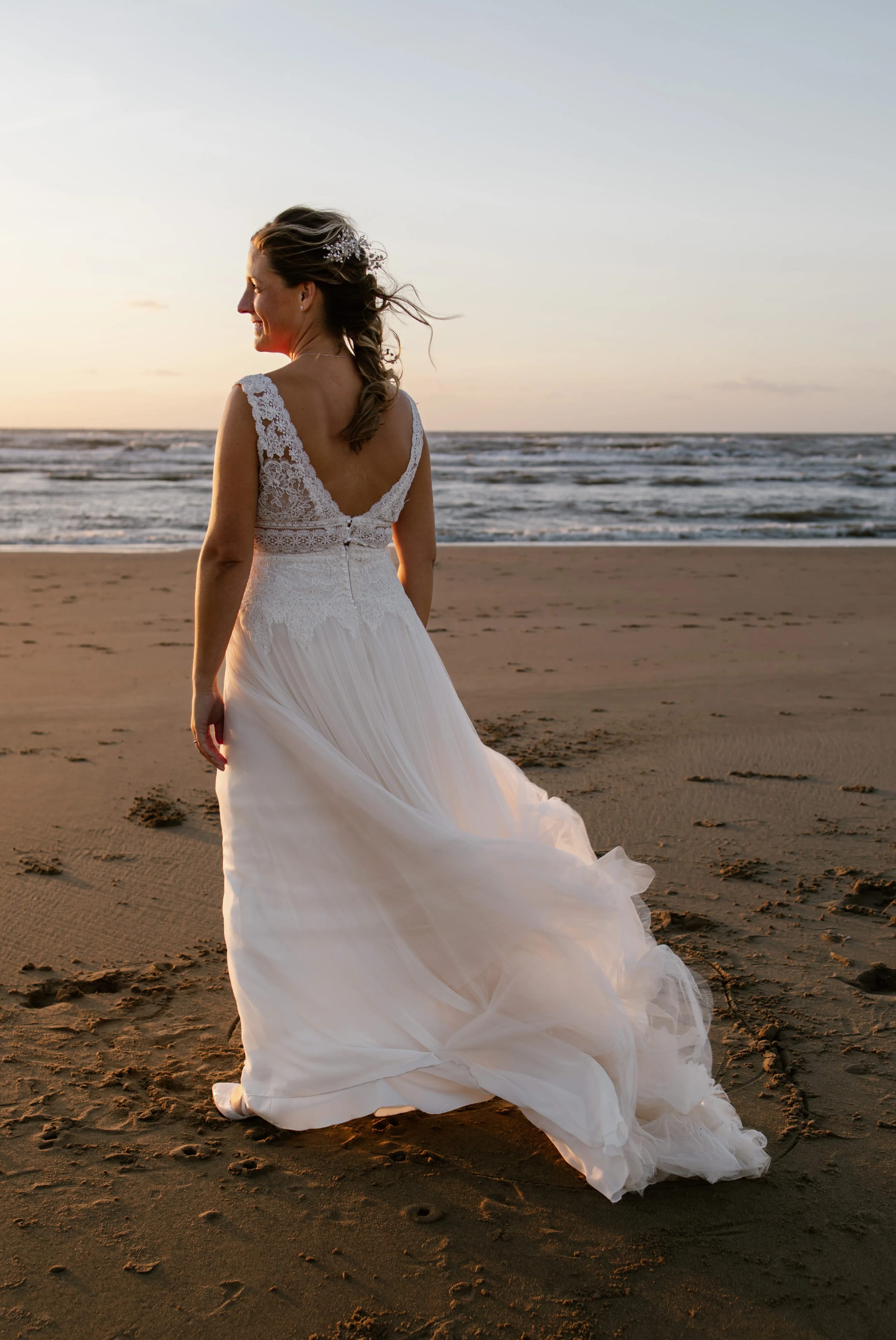 Vrolijk moment van het bruidspaar dat samen danst op het strand