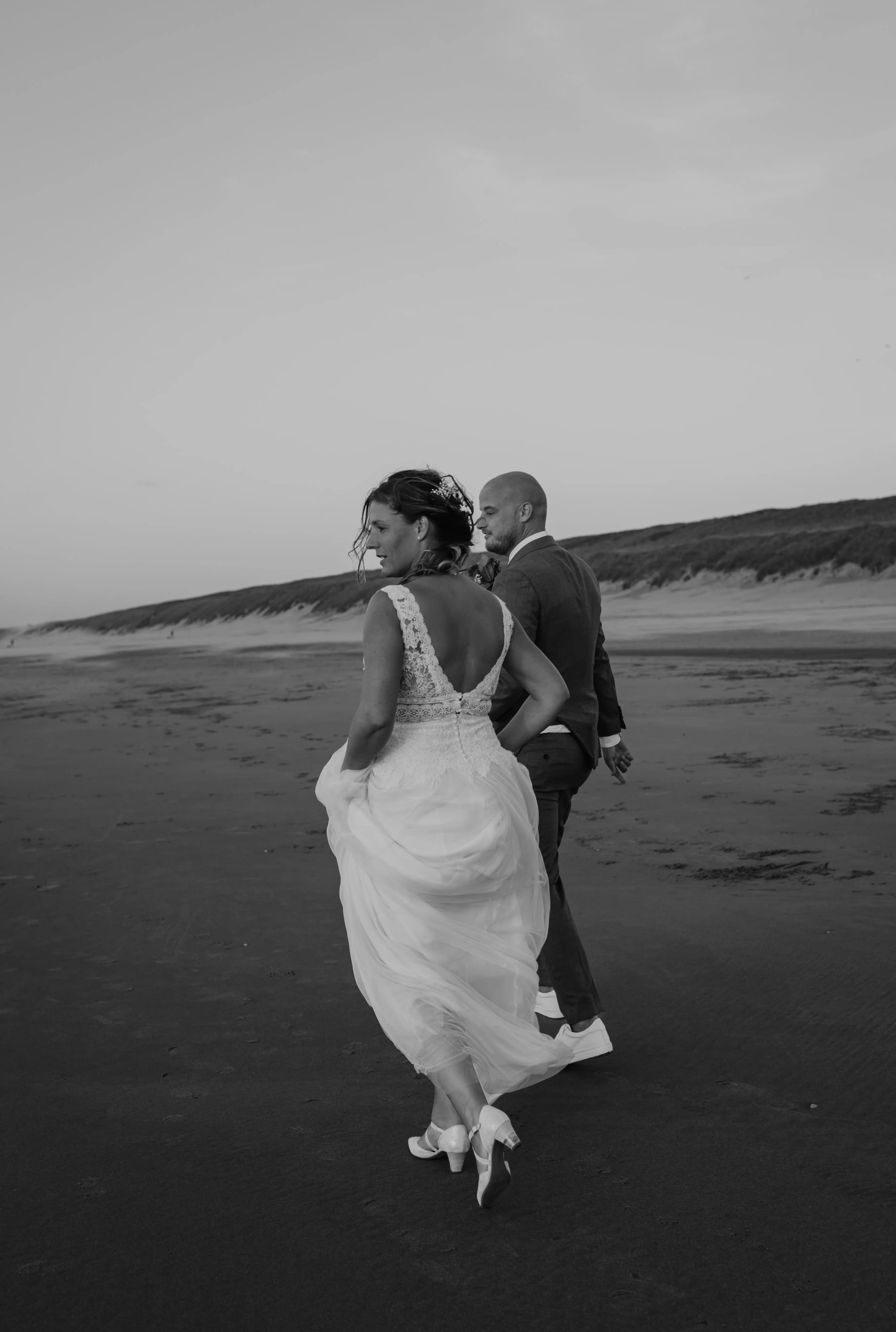 Hein geeft Denise een warme omhelzing van achteren op het strand
