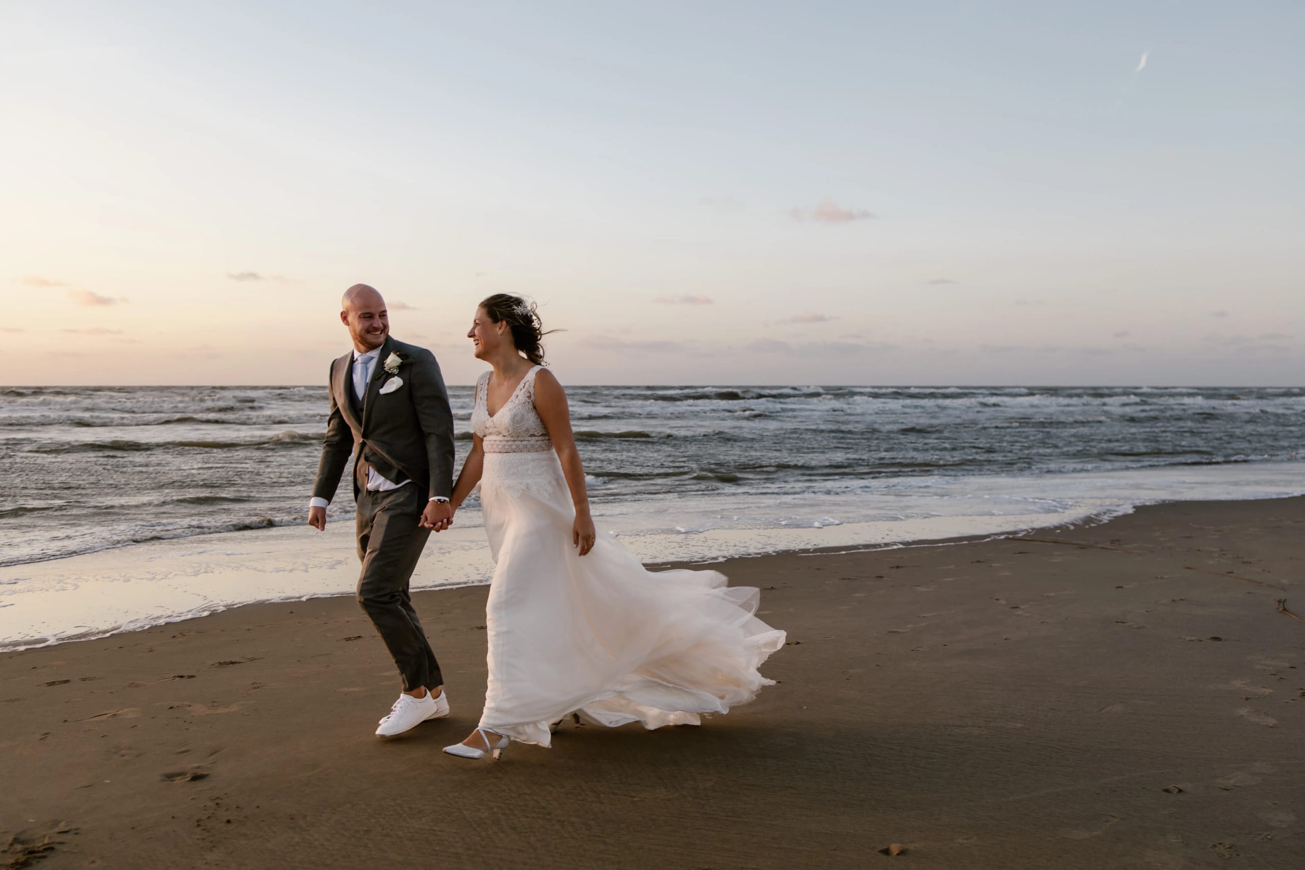 Hein en Denise rennen vrolijk hand in hand over het strand bij de zee