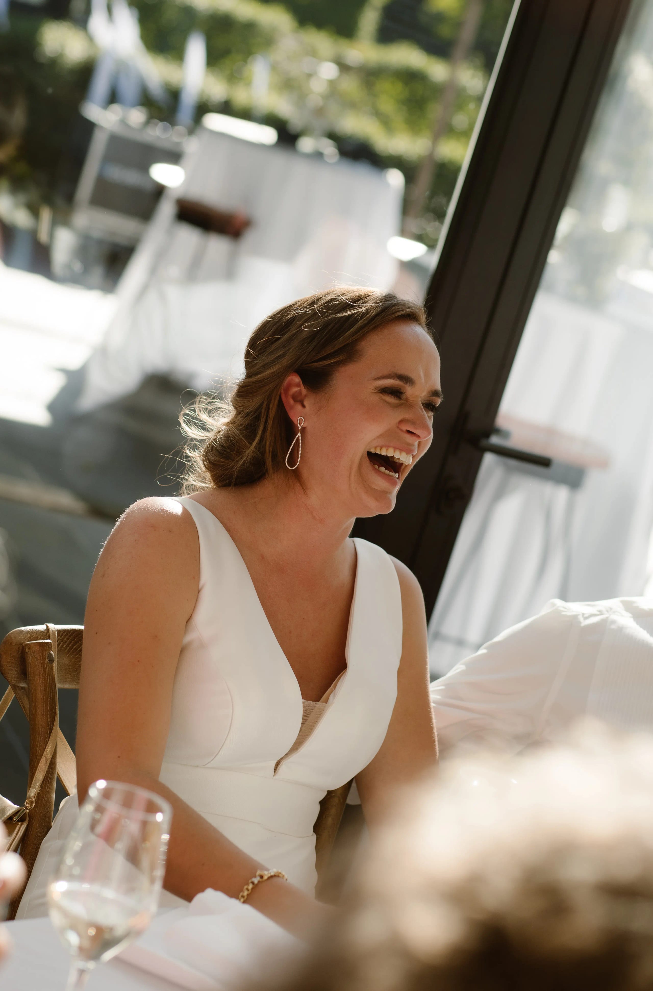 Stralende bruid lacht uitbundig tijdens het huwelijksdiner