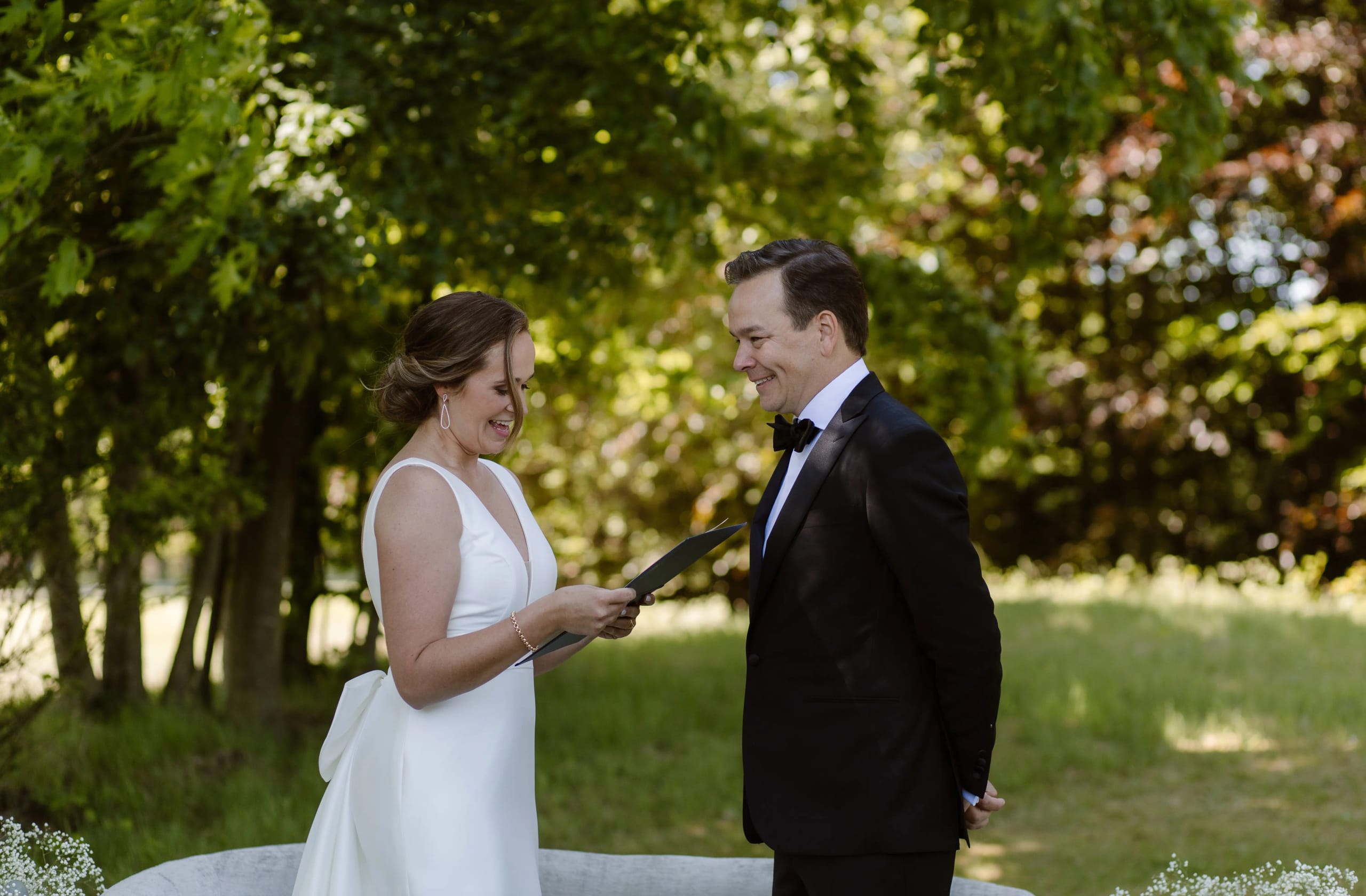 Bruid en bruidegom kijken elkaar verliefd aan in de natuur tijdens de ceremonie