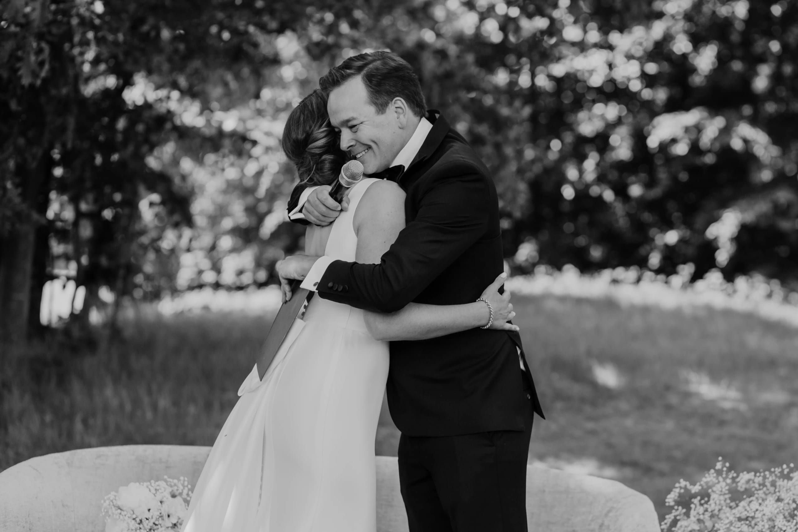 Intieme omhelzing van het bruidspaar na de ceremonie in zwart-wit