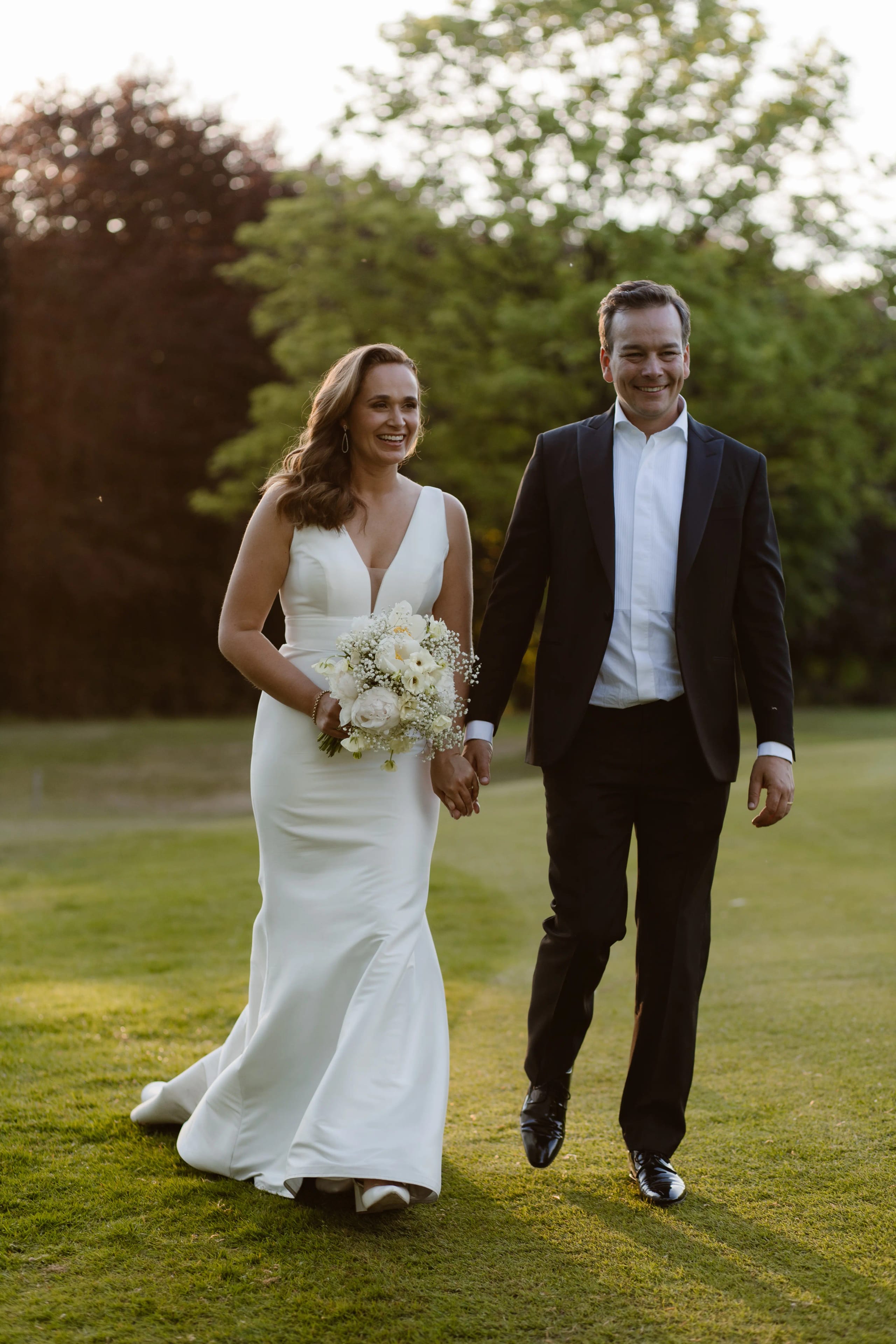 Romantische wandeling van het bruidspaar over het gazon van het kasteeloppervlakte