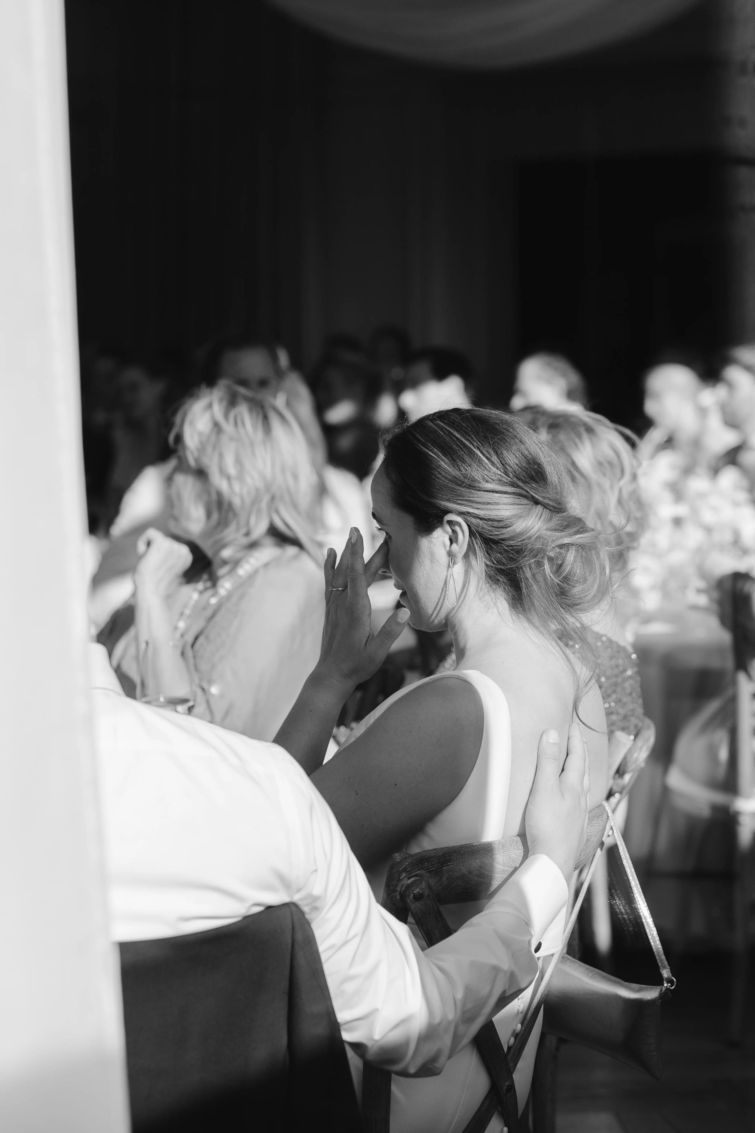 Zwart-wit close-up van de bruid die haar gezicht aanraakt tijdens een emotioneel moment