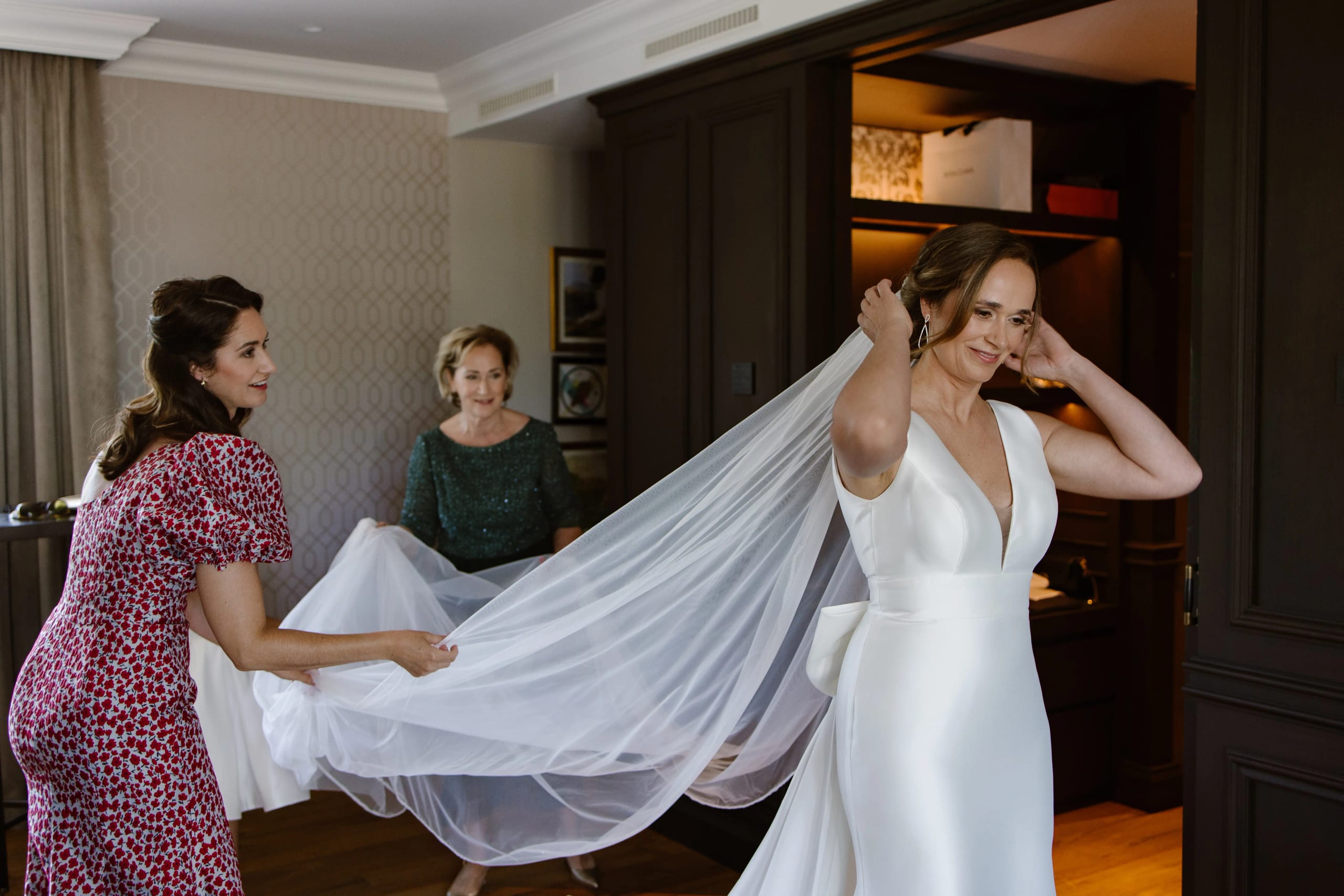 De moeder van de bruid helpt haar dochter met de voorbereiding van de sluier