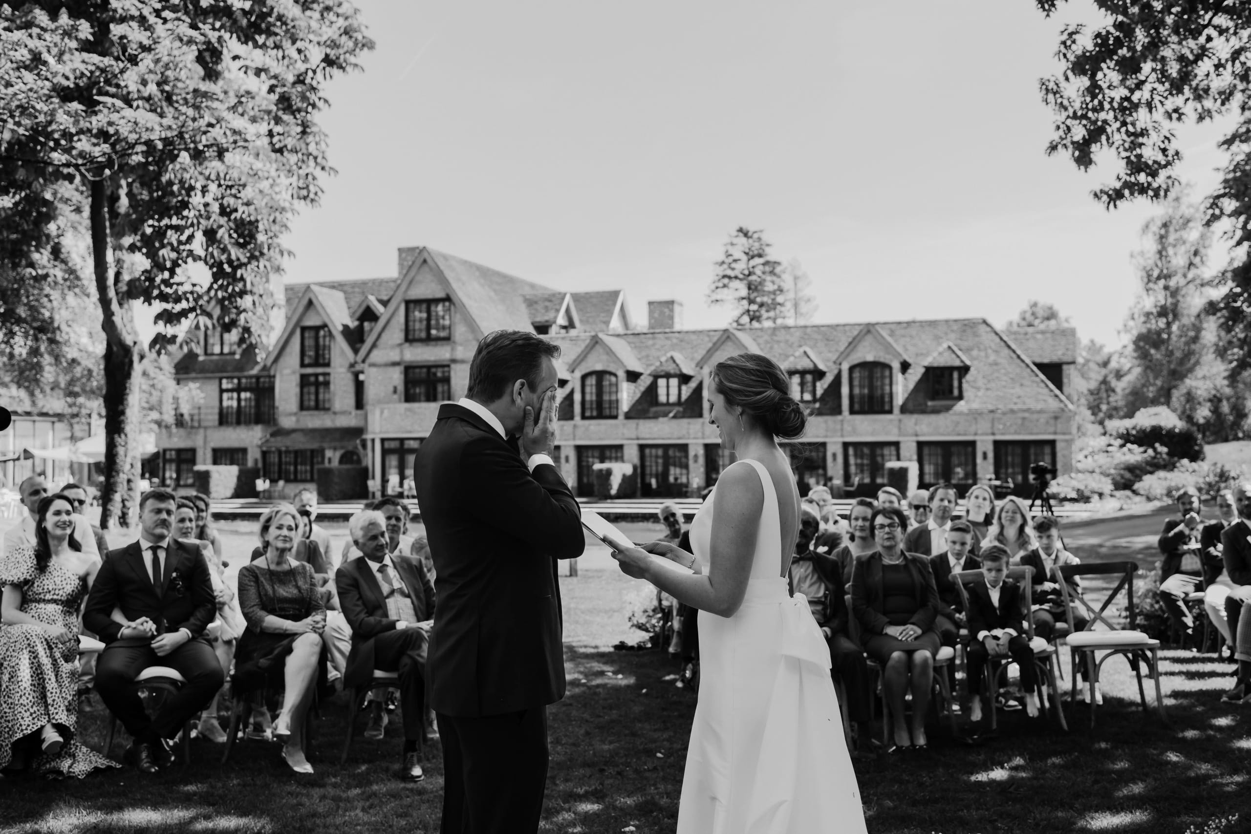 Zwart-wit momentopname van de ceremonie waar de bruid haar gelofte voorleest aan de bruidegom