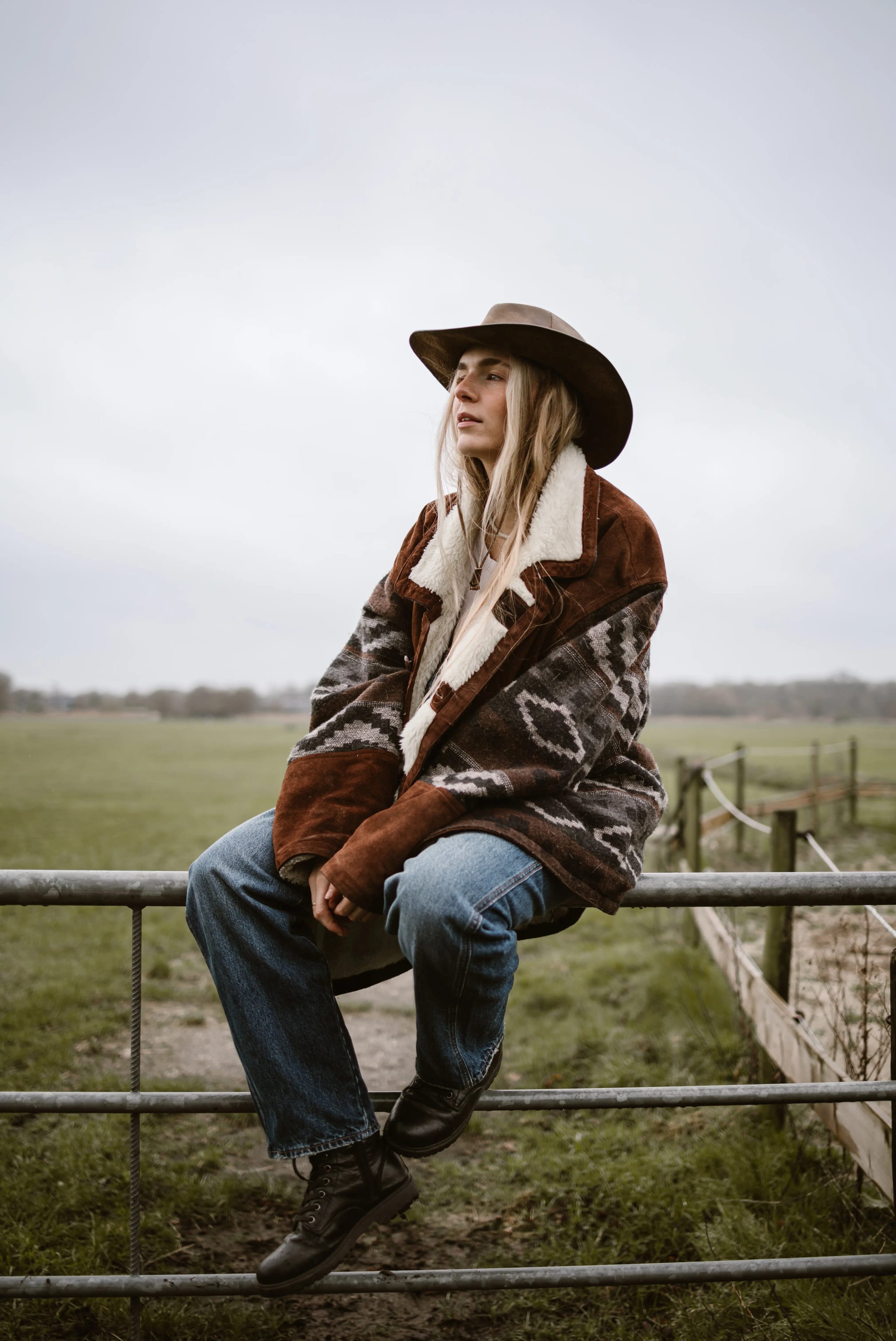 Lies Zhara zittend op een houten hek in een landelijke omgeving