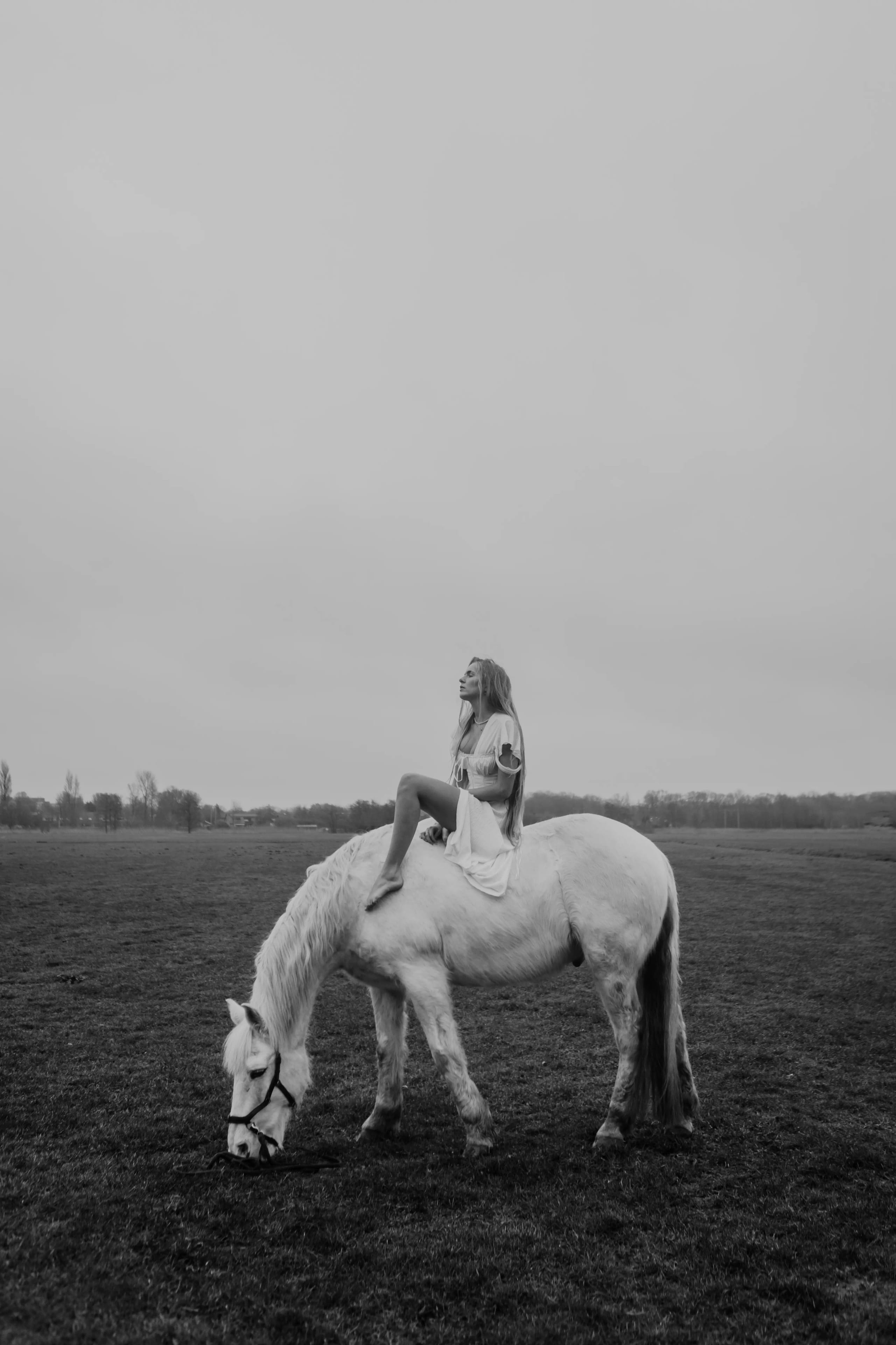 Lies Zhara zittend op een wit paard in een uitgestrekt grasveld