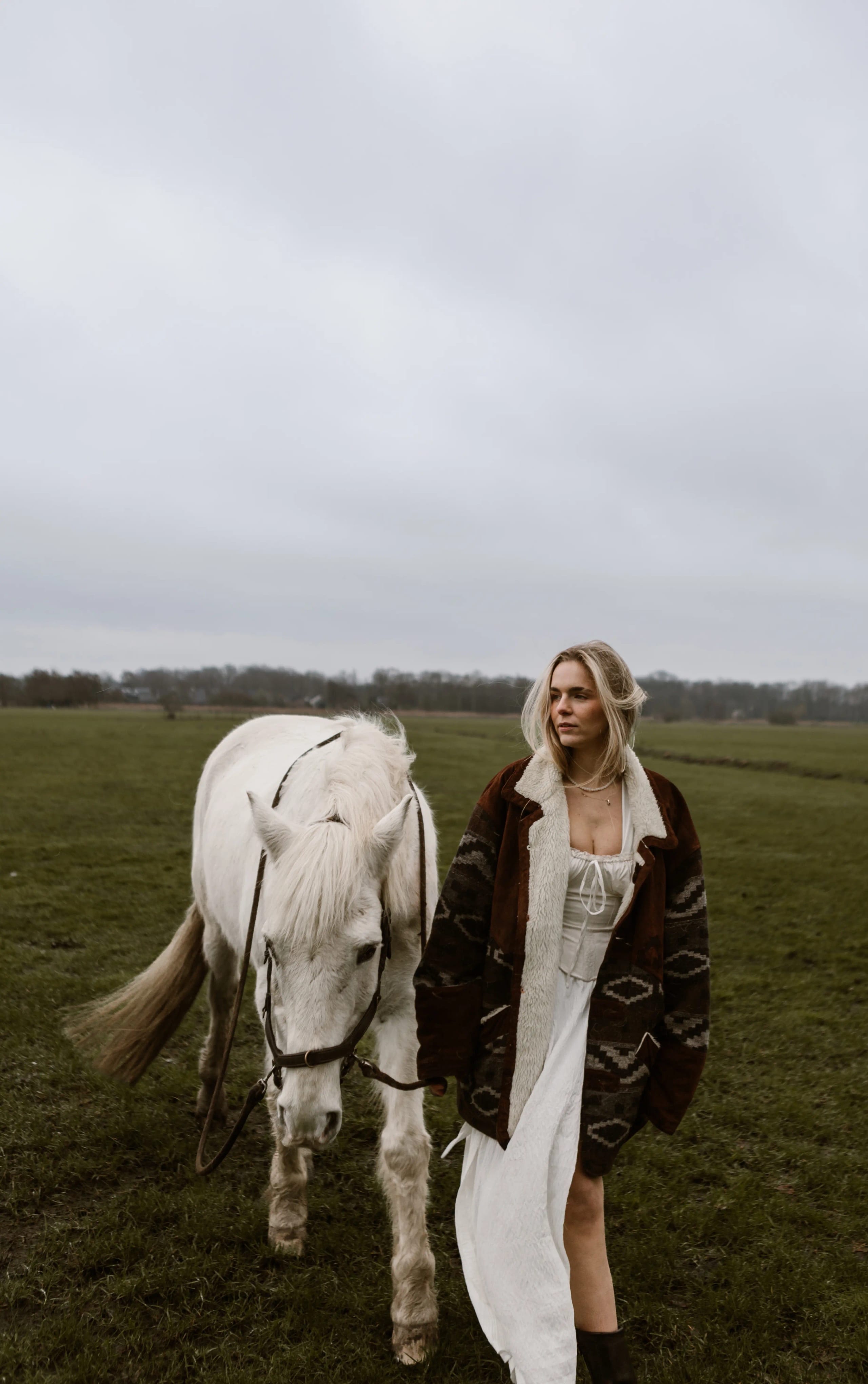 Lies Zhara wandelend met een wit paard in een landschap