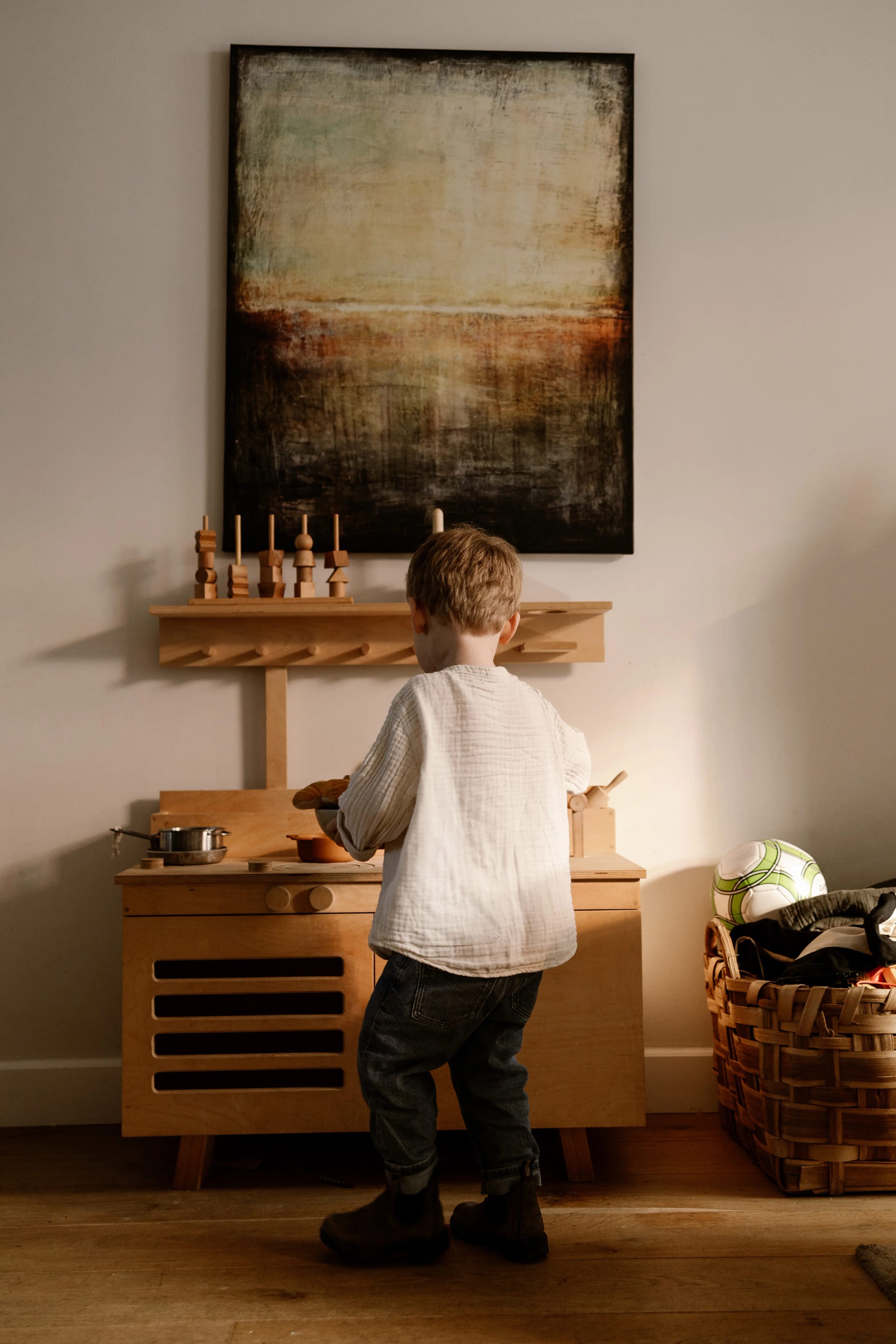 Kind speelt met een houten speelgoedkeukentje, details van een thuis shoot.