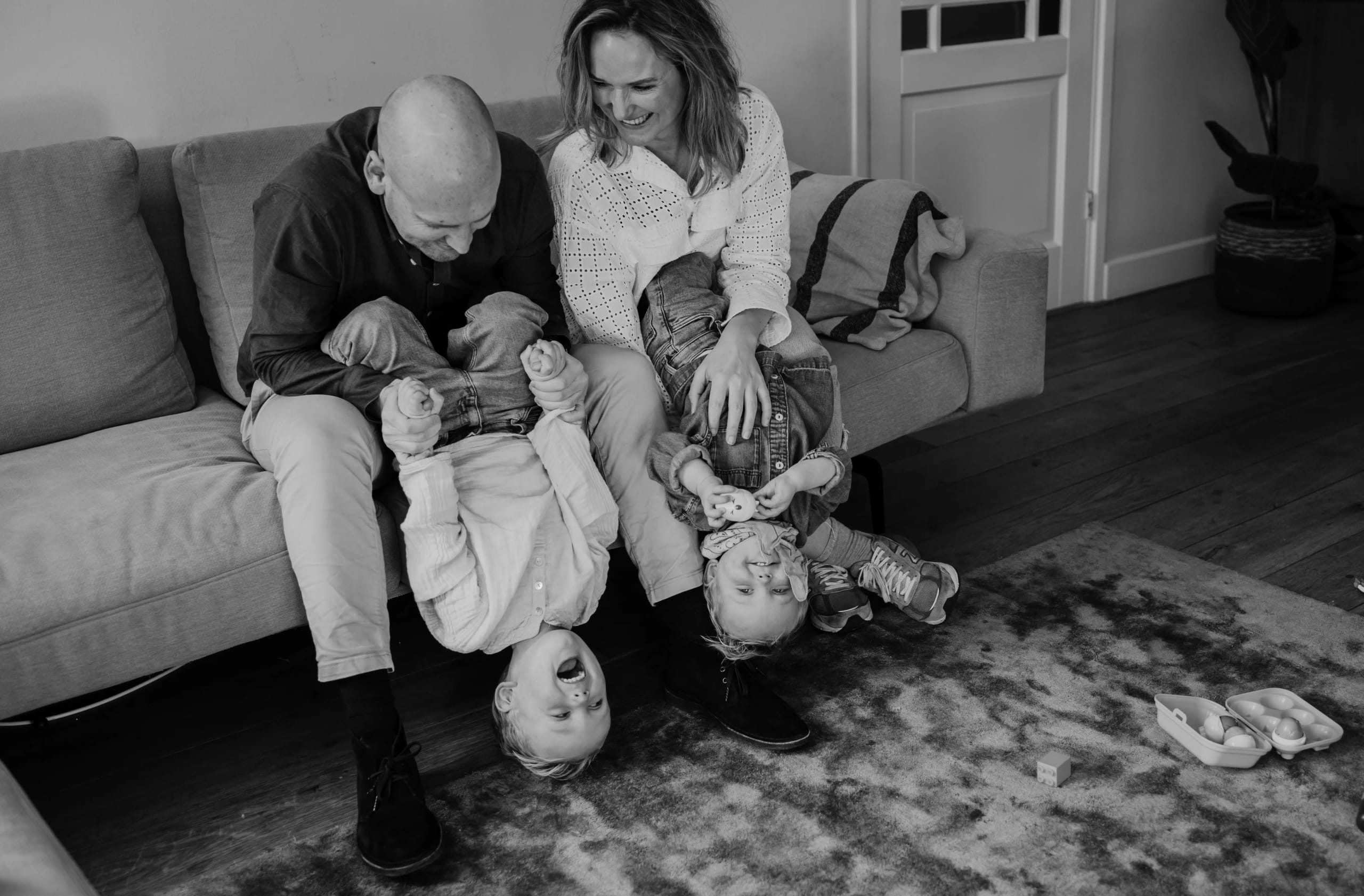 Hele gezin knuffelt samen op de bank, warme herinneringen door Denise B Photography.