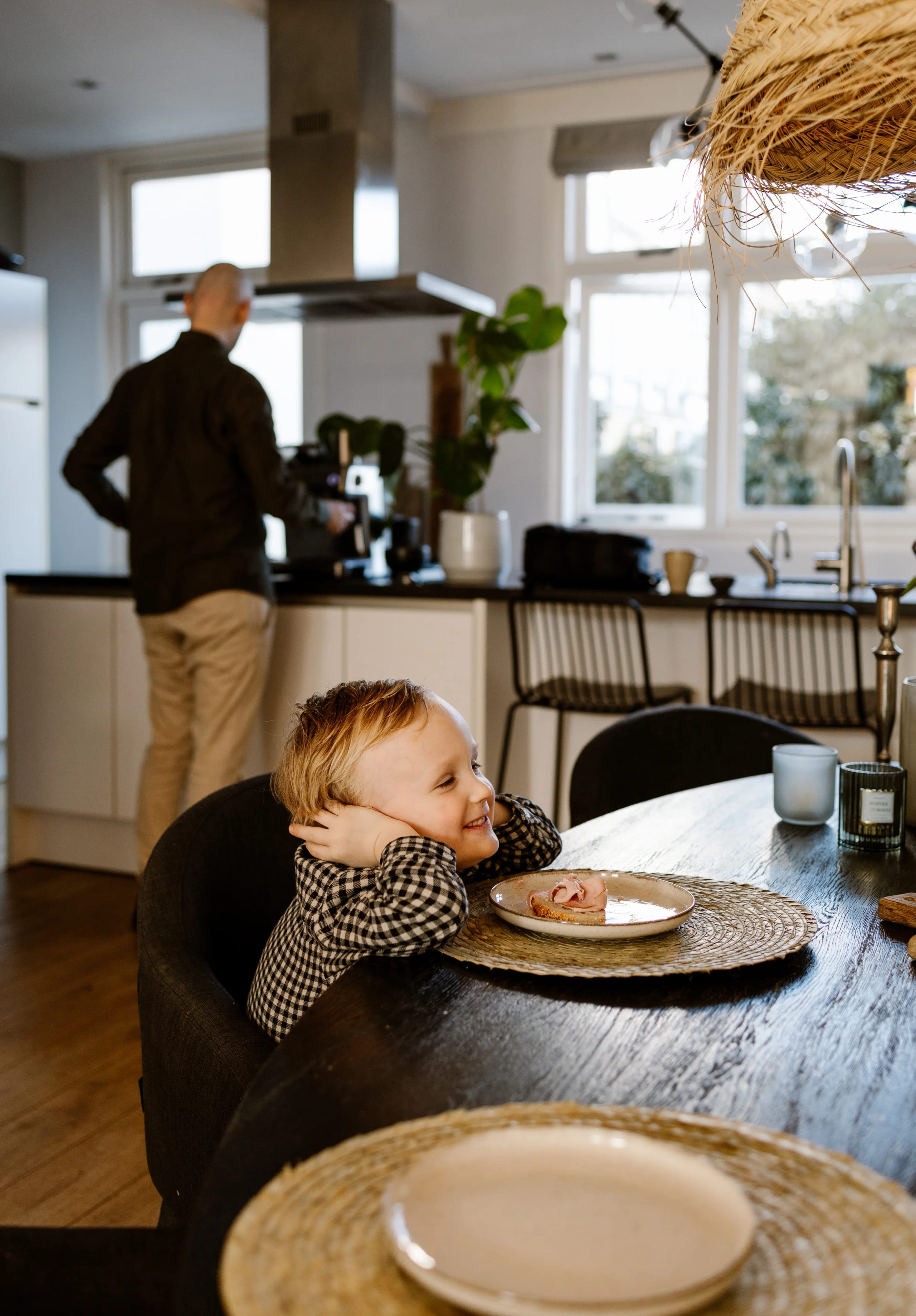Vader in de keuken op de achtergrond terwijl een kind lacht, lifestyle dieptebeeld.