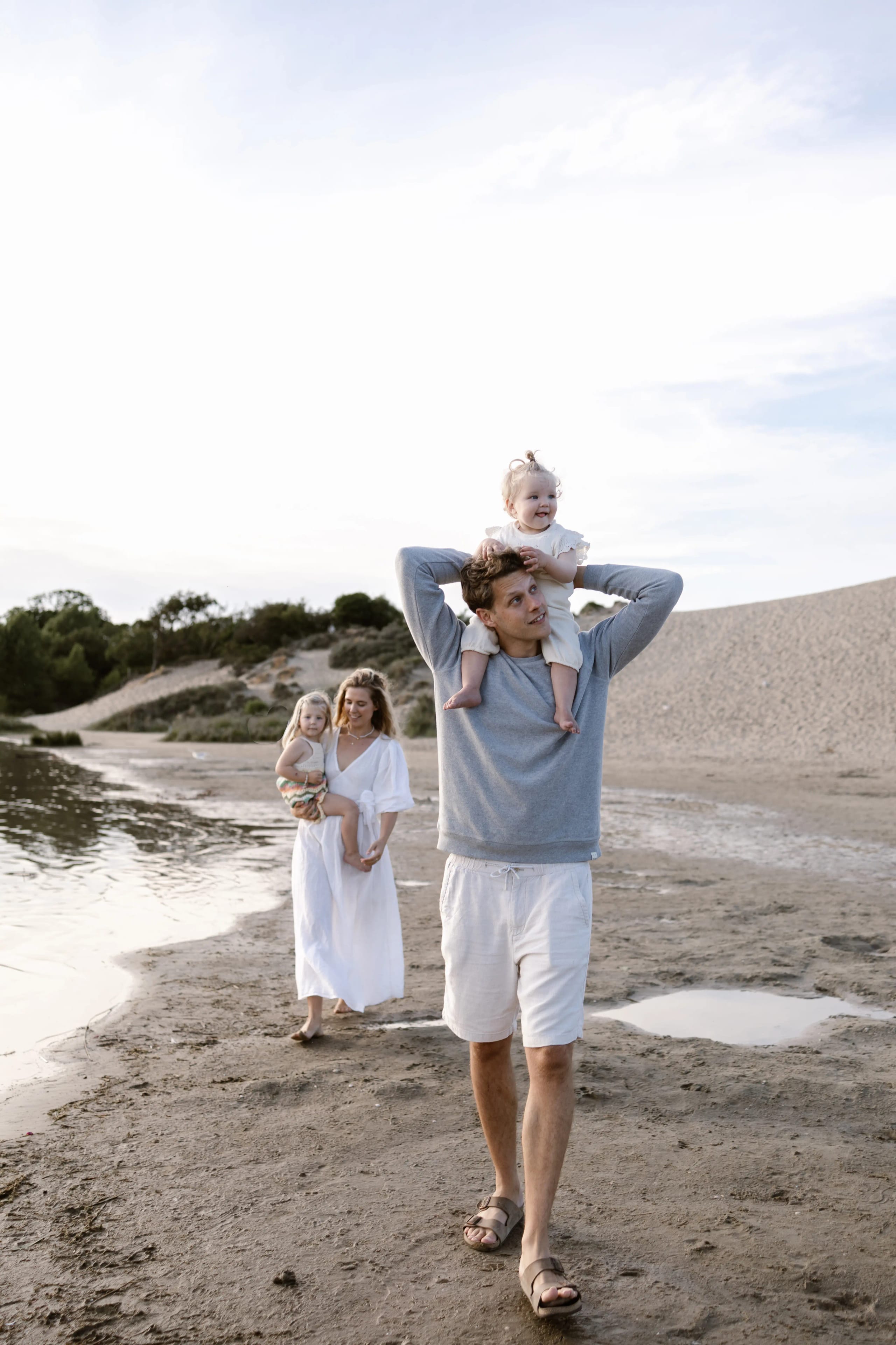 Gezin loopt samen over het strand van Bloemendaal tijdens een zomerse avond fotoshoot door Denise B Photography.