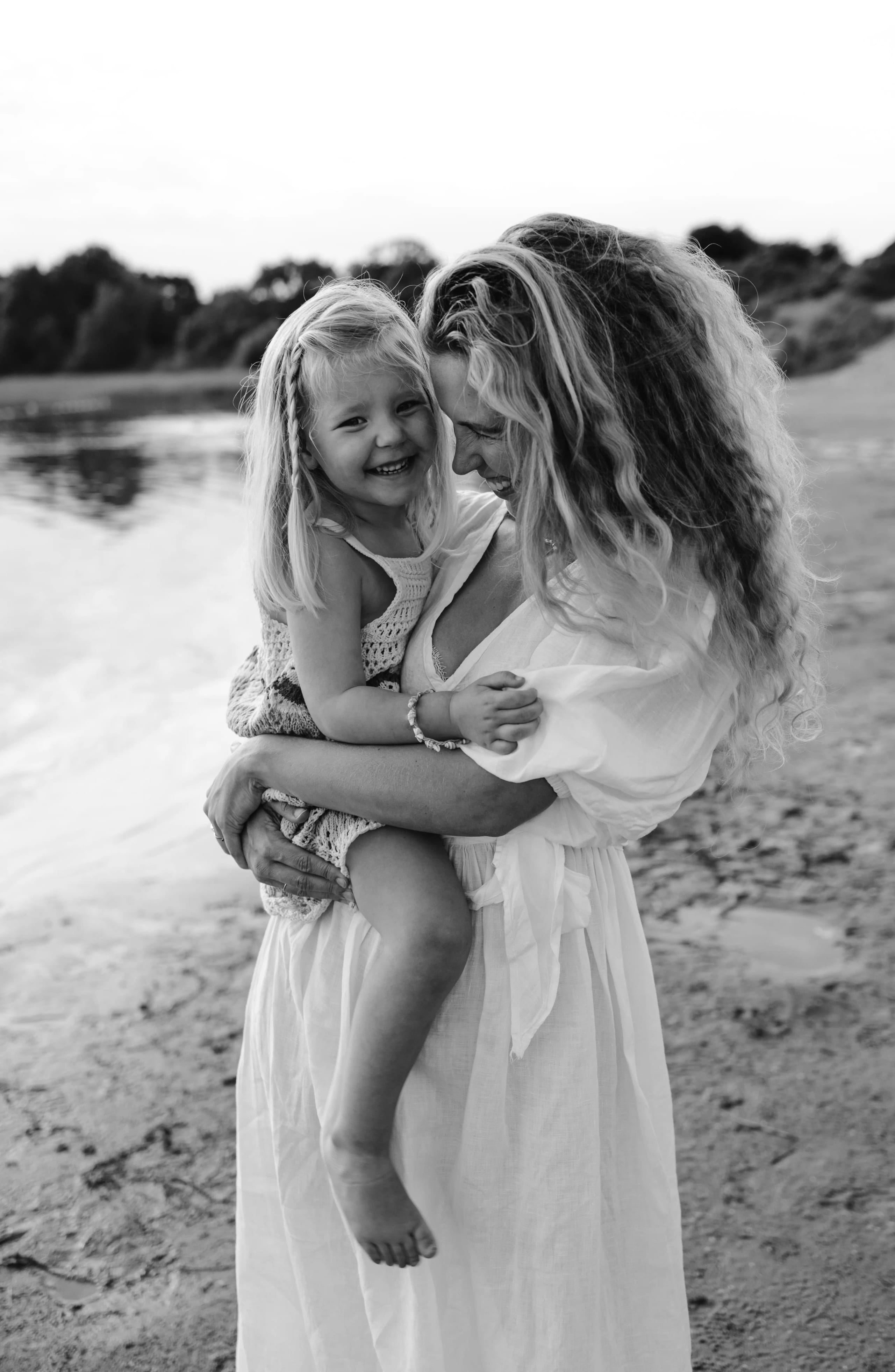 Zwart-wit portret van moeder en kind op het strand bij Bloemendaal, tijdloze familiebeelden.
