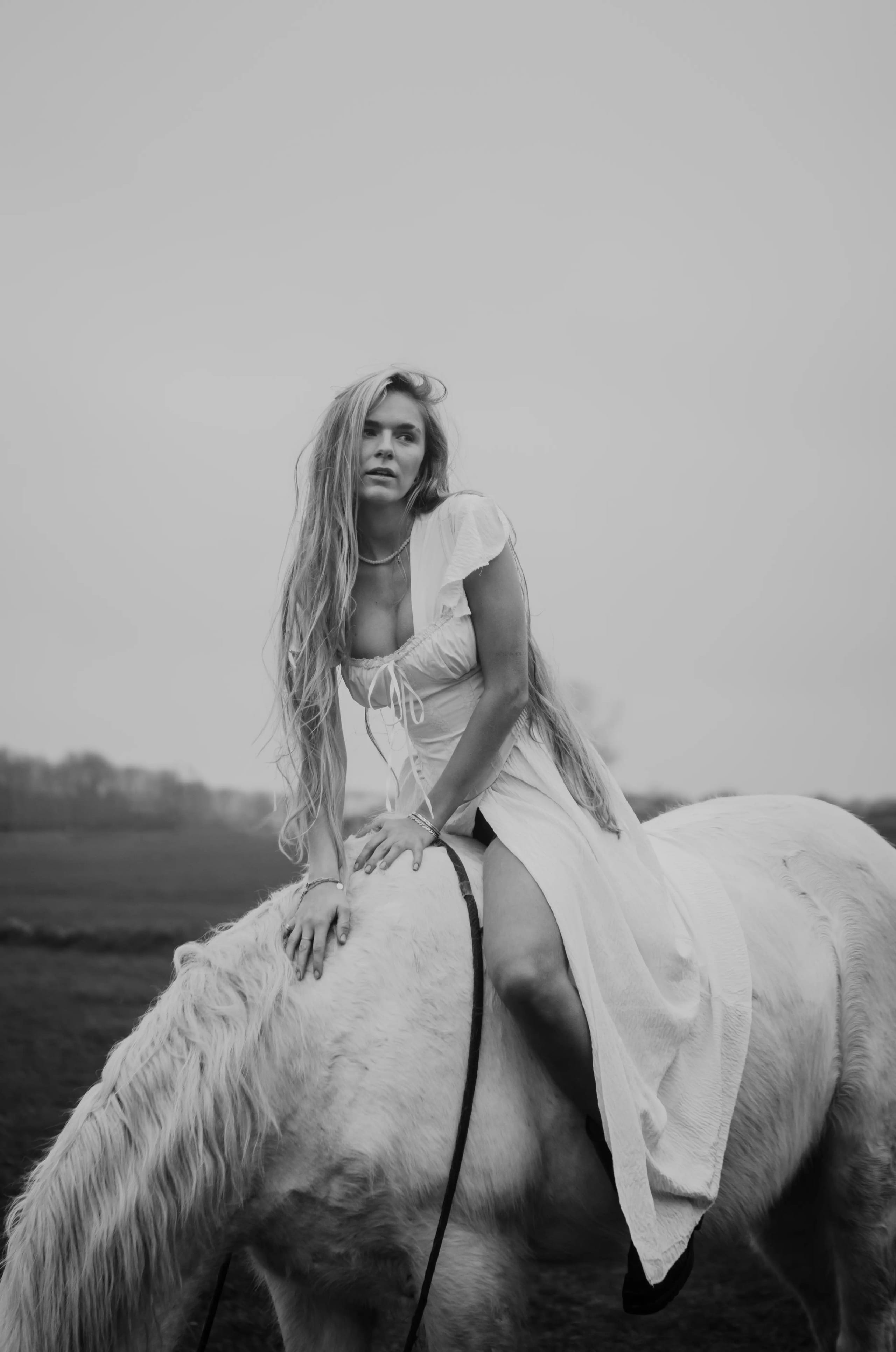 Elegante foto van Lies Zhara in een witte jurk op een wit paard