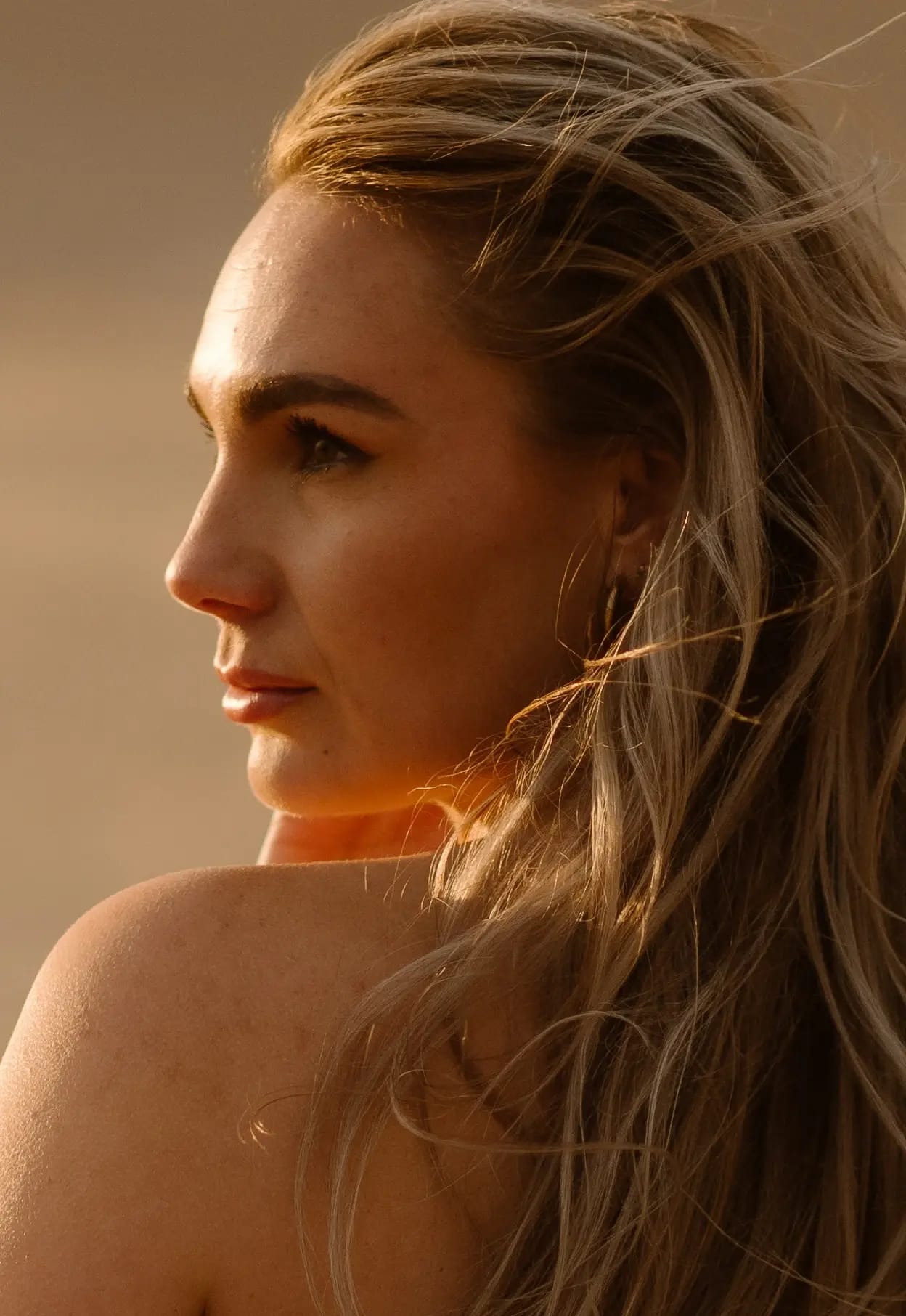 Close-up boudoir portret van Sammy in de duinen met warm tegenlicht van de zon