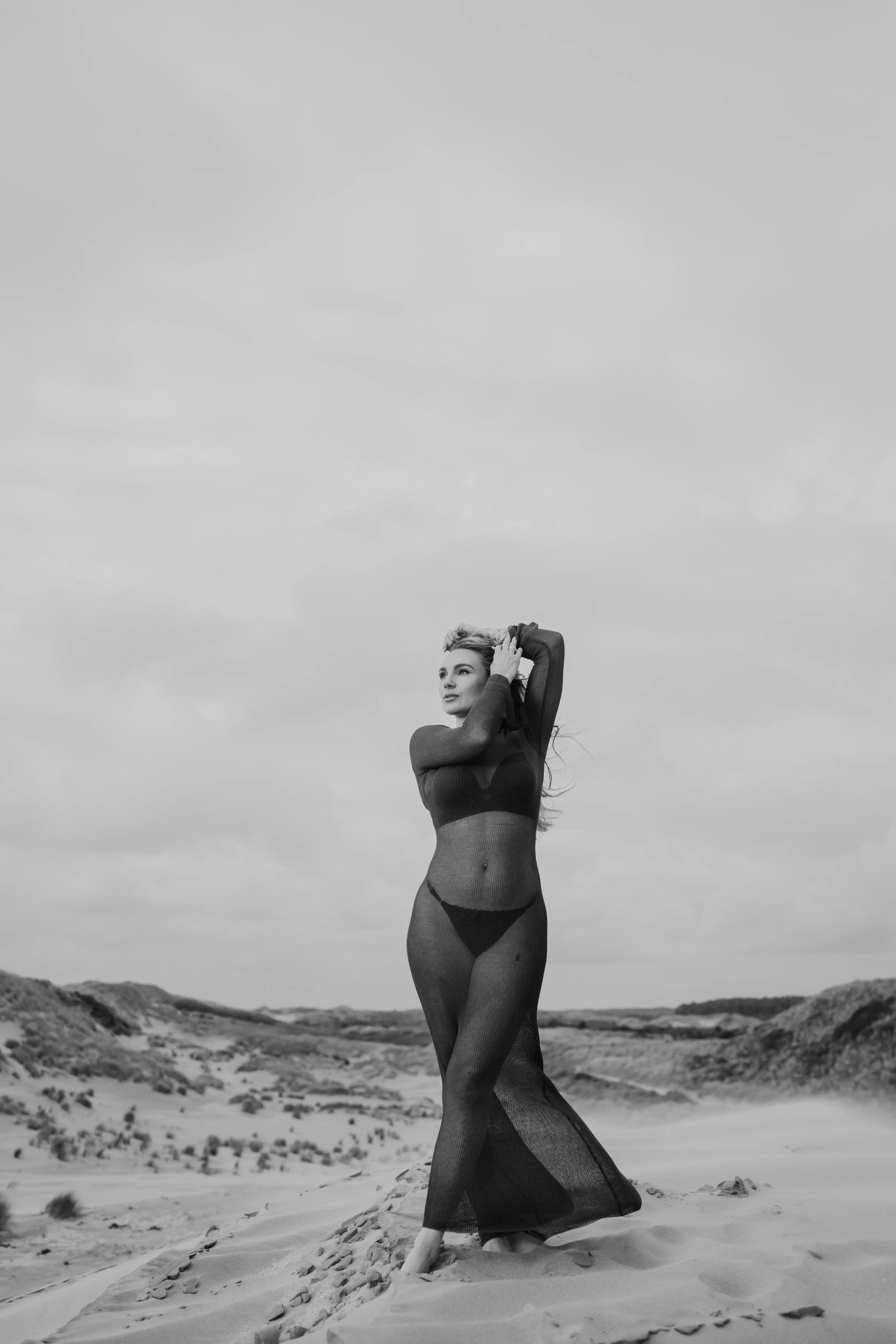 Artistieke zwart-wit boudoir foto van Sammy in het duinlandschap