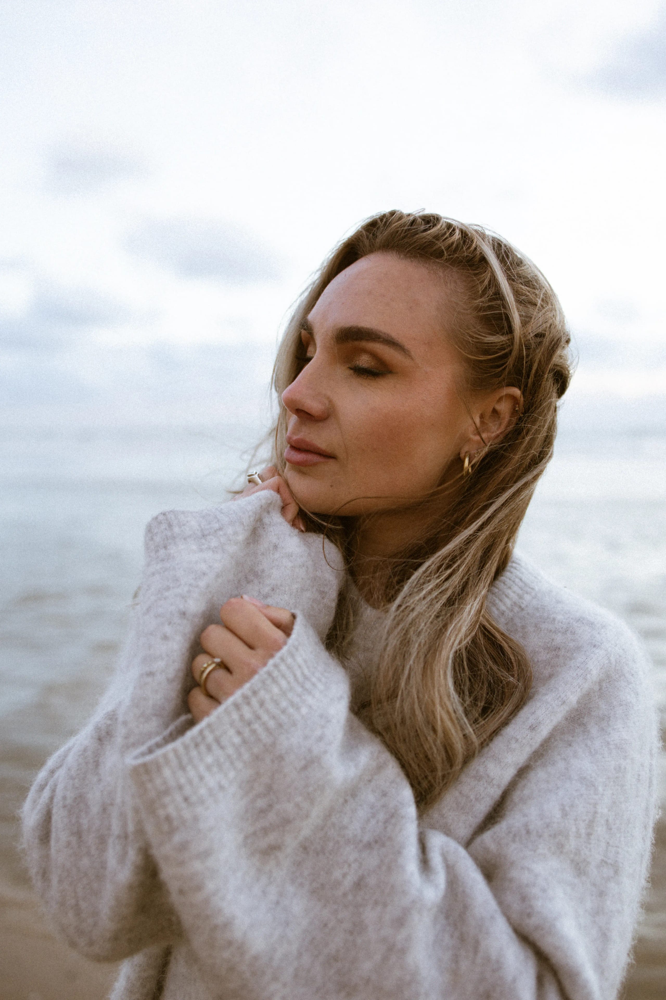 Close-up boudoir portret van Sammy in een grijze trui op het strand van Bloemendaal